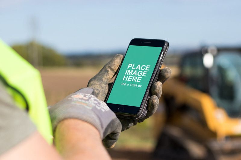 Construction worker typing on iPhone 8