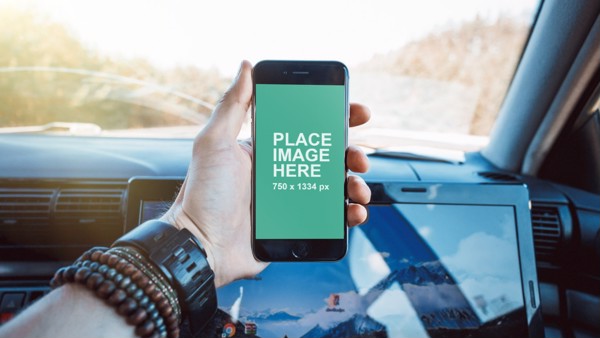Man holding iPhone in car