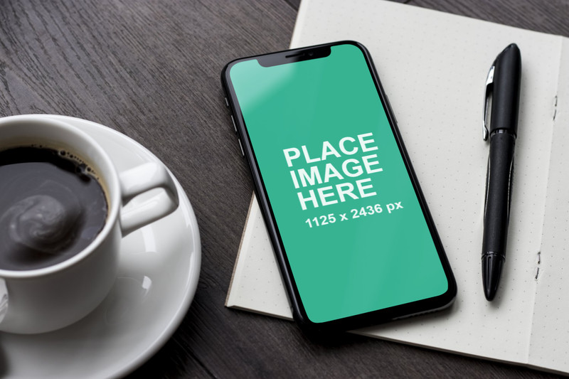 iPhone X on table with coffee