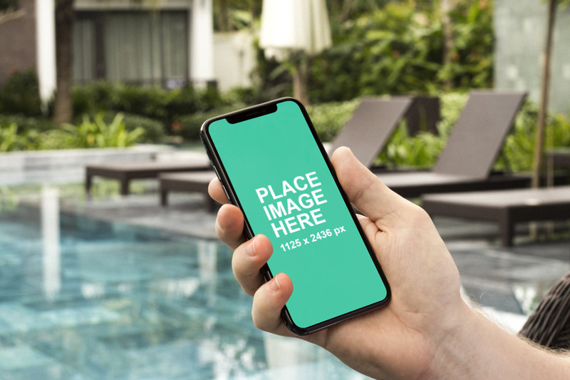 Man holding iPhone X at pool