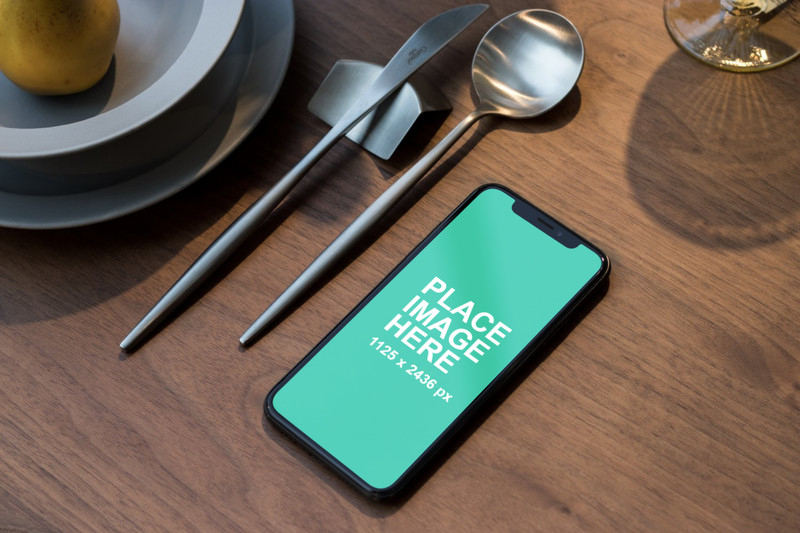 iPhone X with spoon and knife