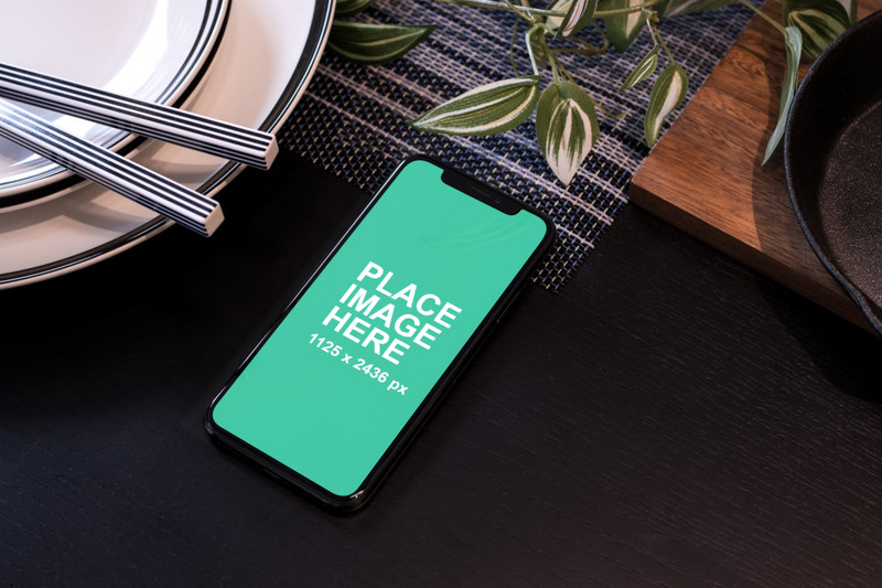 iPhone X on table with cutlery