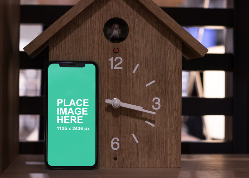 iPhone X standing with clock