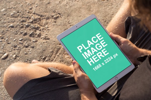 Man using iPad on beach
