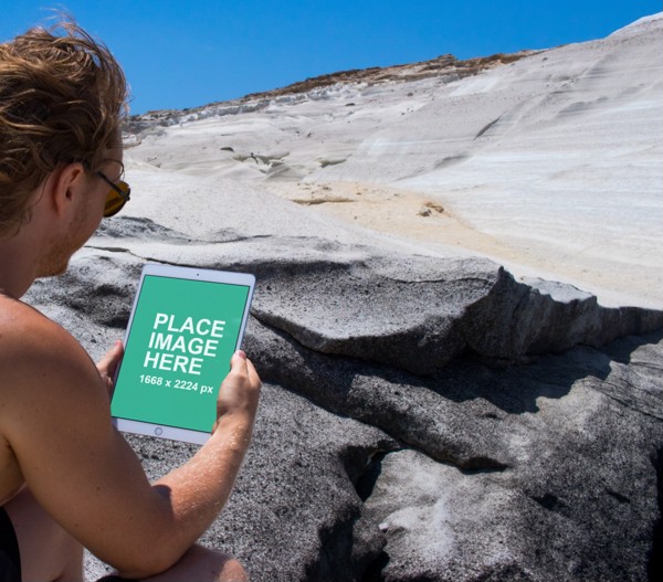 Man using iPad on beach