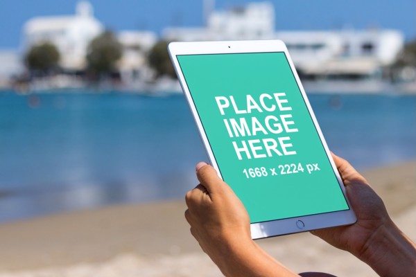Woman using iPad on beach