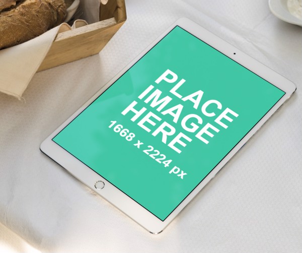 White iPad laying on white table