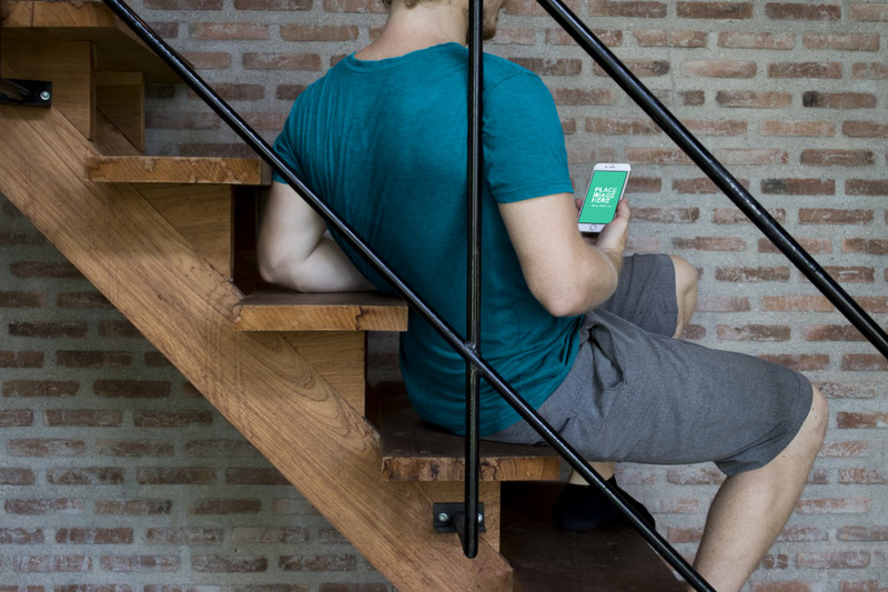 Man looking at iPhone on stairs