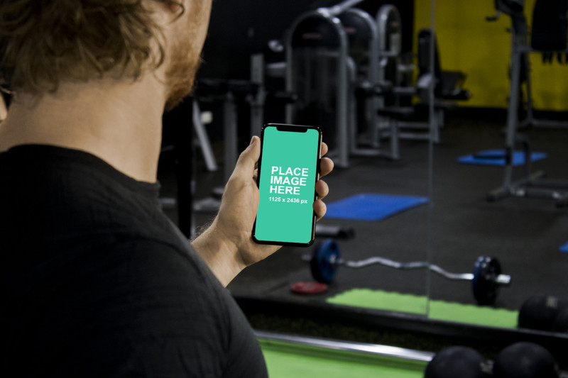 Man holding iPhone X in gym