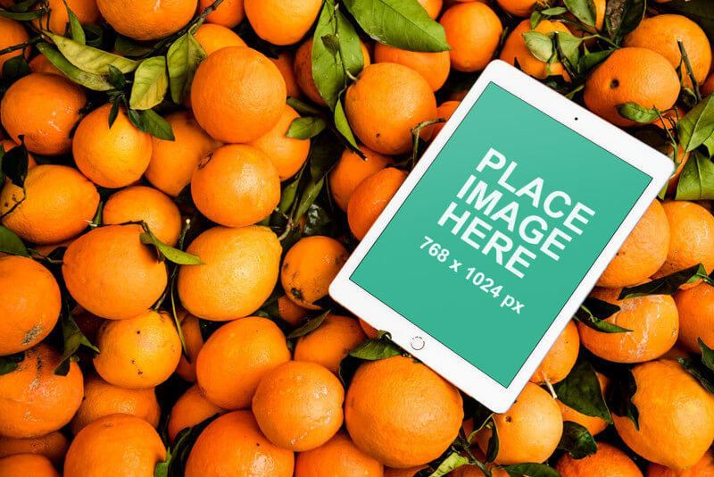 iPad on bed of oranges