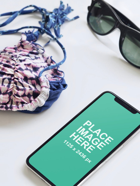 iPhone X and sunglasses on desk