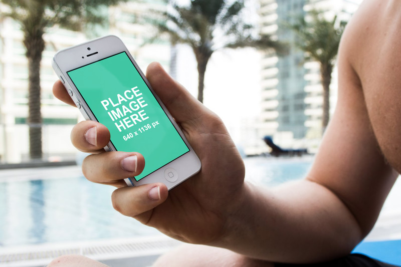 Man holding iPhone at pool