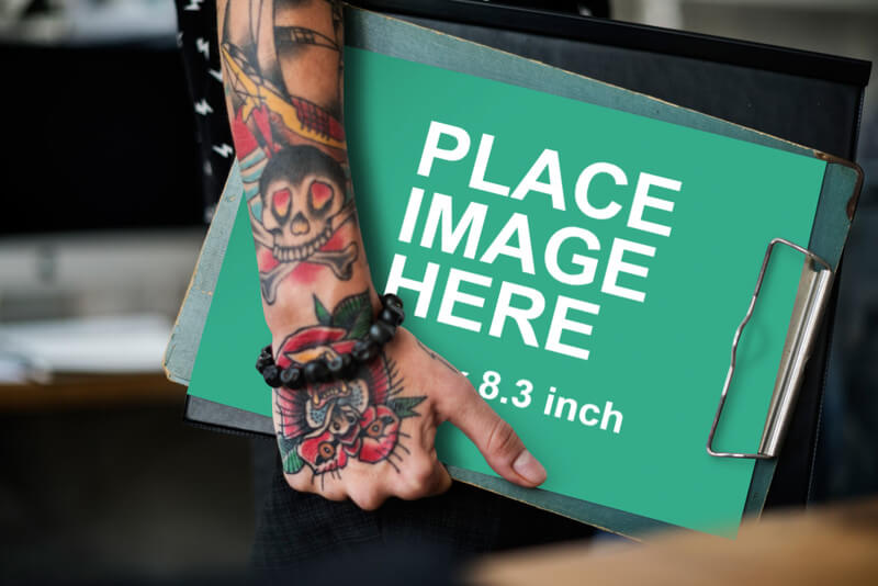 Tattooed woman holding A4 paper
