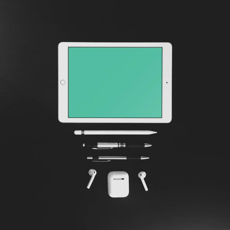 White iPad on black desk