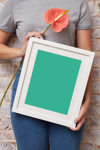 Woman holding white frame
