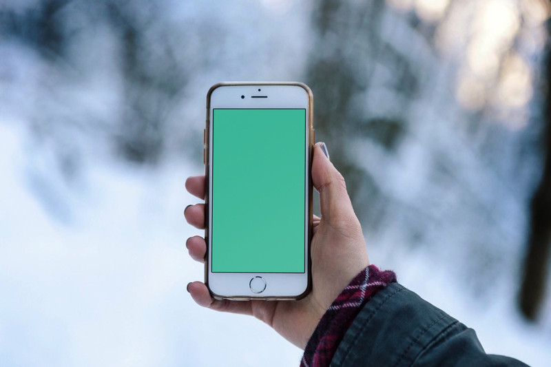 Woman holding iPhone outdoors
